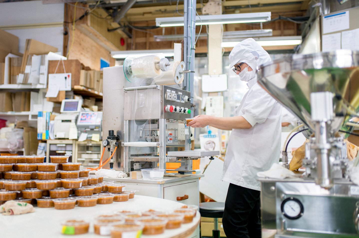 Worker in a food processing factory packaging food