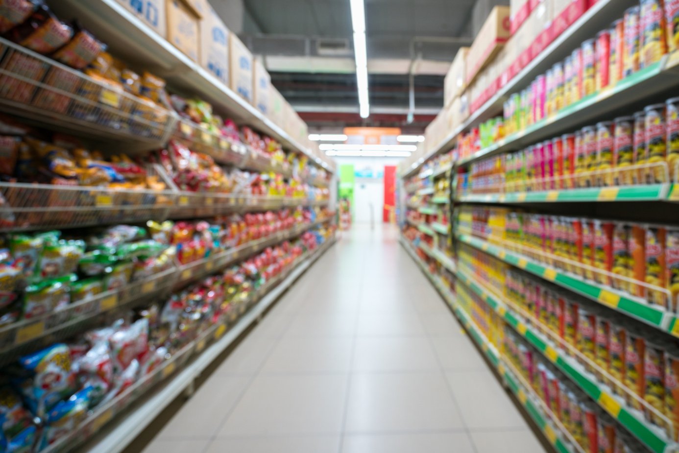 Supermarket Blurred Background with Colorful Shelves and Unrecognizable Customers